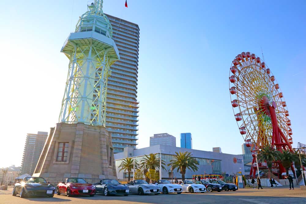信号所と観覧車を背景に並ぶロードスター