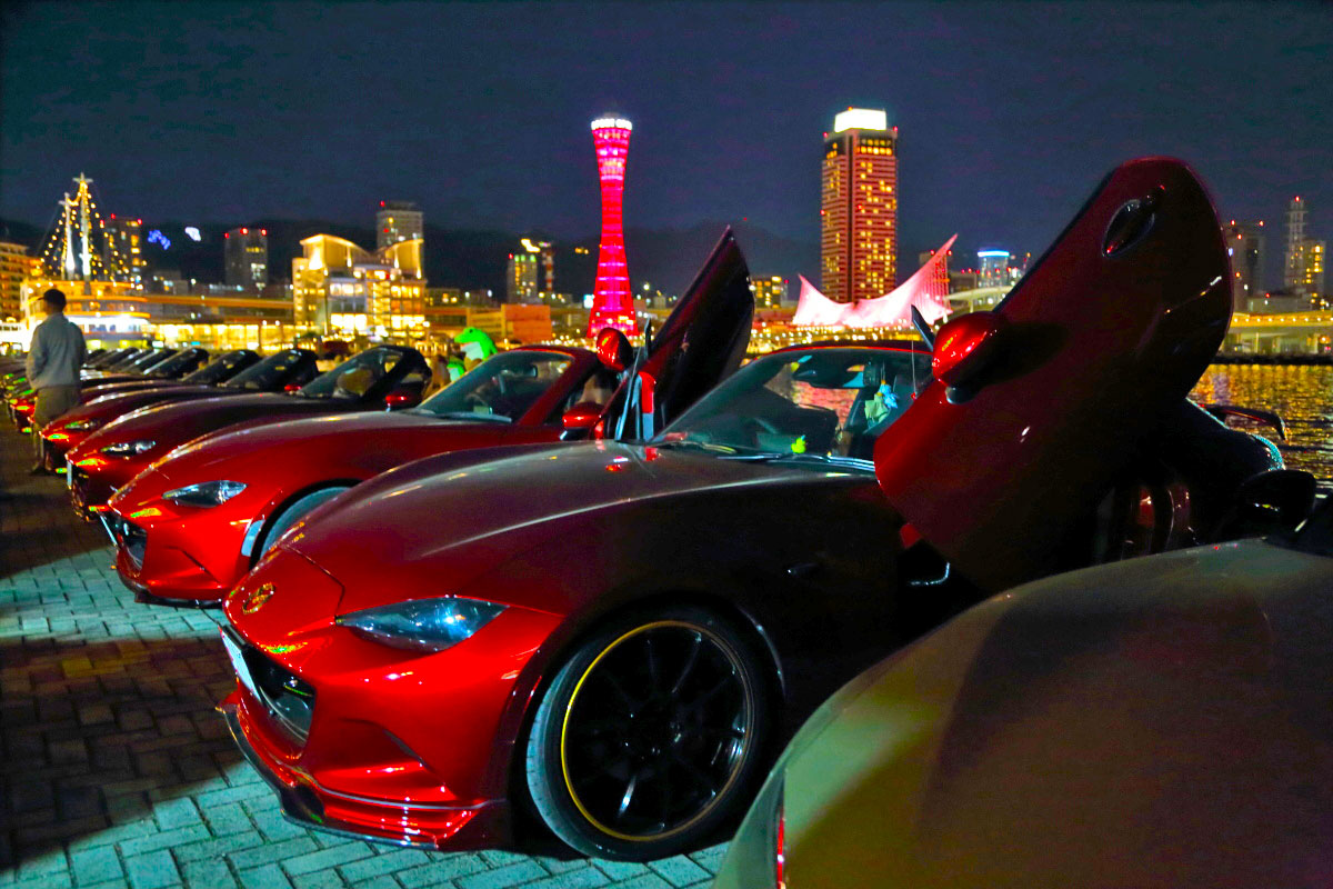 夜景に溶け込むソウルレッドのロードスター