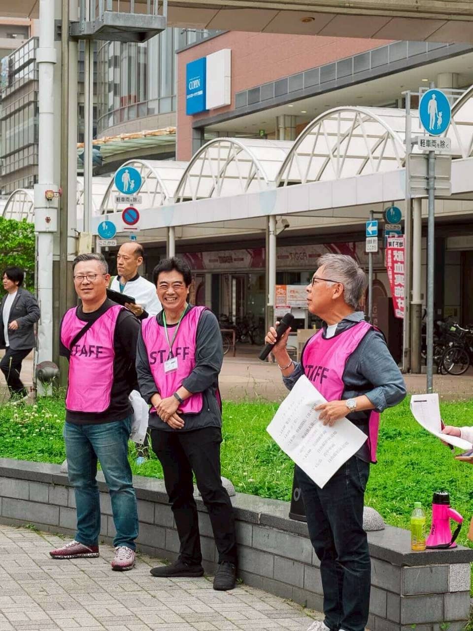 新長田駅前を歩くピンクのSTAFFベストの運営メンバー3人
