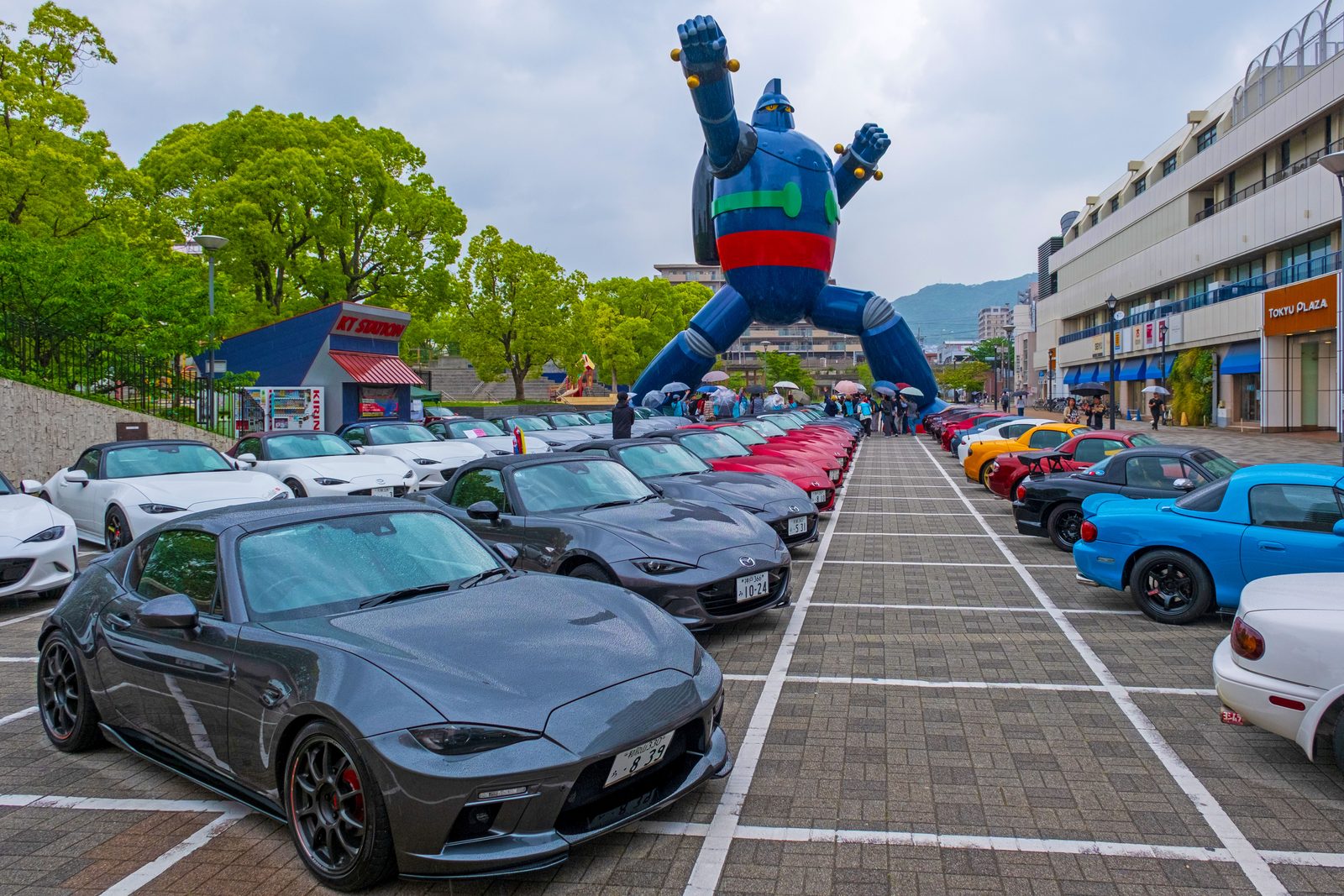 鉄人28号の足元に並ぶロードスターの車列