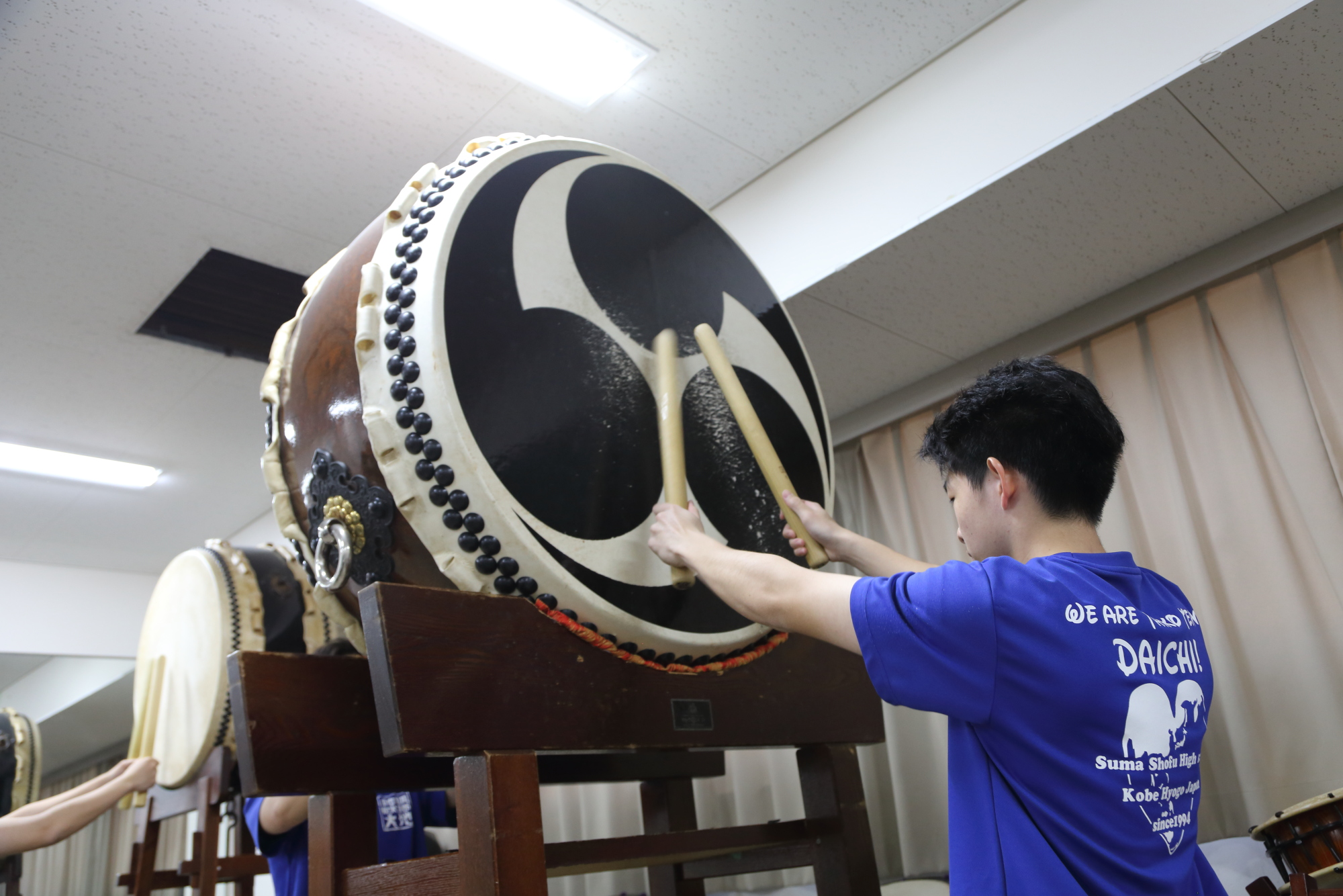 巴紋の大太鼓を演奏する部員